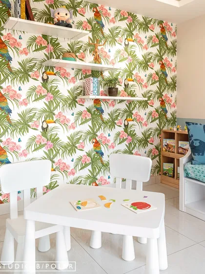 A playroom from one of our early projects, featuring a vibrant tropical wallpaper with parrots and toucans. The space is designed to be bright, cheerful, and full of energy.