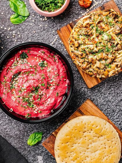 Our vegan delights make vegetables the star. This beautiful spread of beetroot hummus and a healthy pizza shows that plant-based goodness can be exciting and delicious.