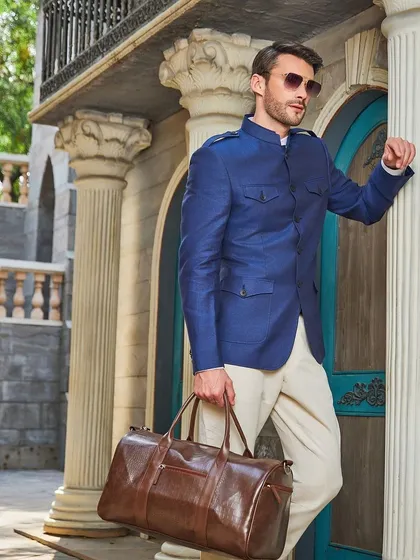 The perfect travel or destination wedding outfit. The linen bandhgala jacket is both breathable and impeccably stylish, shown here with a leather weekender bag.