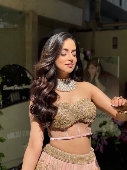 A sun kissed shot of a client with glamorous, bouncy waves. The side part and voluminous curls create a very flattering, classic party look.