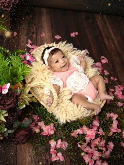 A happy baby girl surrounded by a sea of pink flowers. Her bright smile and the whimsical butterflies create a truly magical and joyful garden scene.