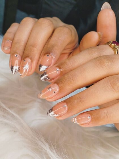 A close-up detail shot of the silver chrome starburst nail art.