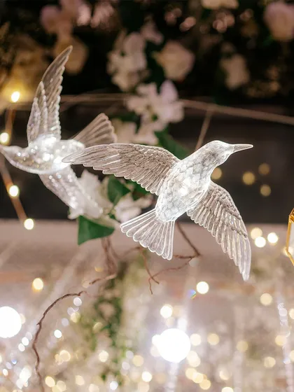 Our commitment to detail is what sets our decor apart. These delicate, illuminated crystal birds, nestled within a floral arrangement, add a touch of whimsy and magic, creating intricate layers of beauty for guests to discover.