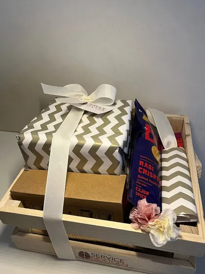 Another view of the wooden crate birthday hamper, showing the mix of snacks and wrapped gifts. It’s a thoughtful gesture for both in-office and remote employees.