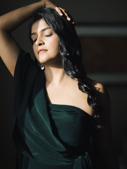 This artistic shot highlights the beautiful draping of the jumpsuit. It's a perfect example of how the right outfit can create a powerful and memorable image.