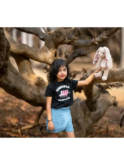 Posing with her bunny friend against a beautifully textured tree. This photo from Brishka's seventh birthday shoot has a magical, woodland feel, highlighting her connection with nature.
