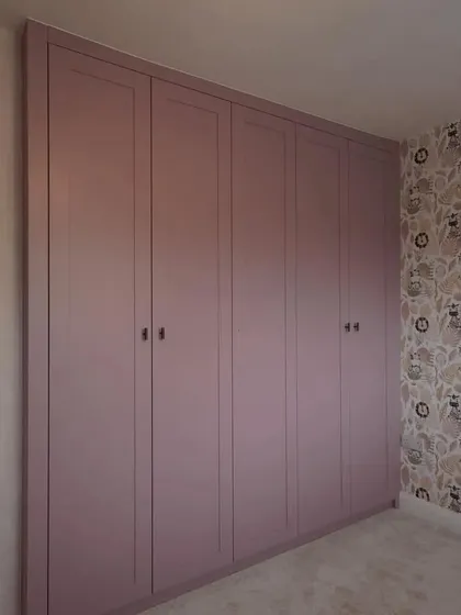 The closed wardrobe presents a seamless and elegant facade, with subtle paneling details that add a touch of classic charm to the modern design.