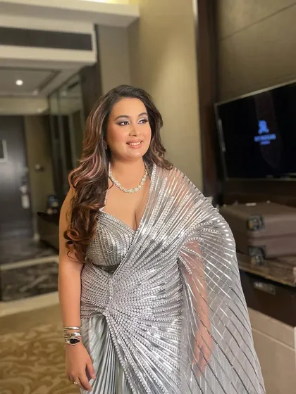 The full look of the client, her hair styled in glamorous waves that complement her modern outfit.