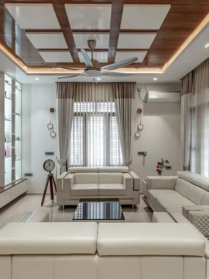 We believe a home's interior should be a sanctuary. This living room showcases our approach to interior design, using a calm color palette, luxurious textures, and a coffered ceiling to create a space that is both elegant and welcoming.