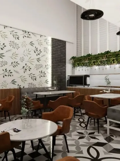 Here you can see the interplay of different textures in the cafe design. The exposed brick-style wall, the leafy wallpaper, and the smooth marble-top tables create a rich, layered look that is both modern and comfortable.