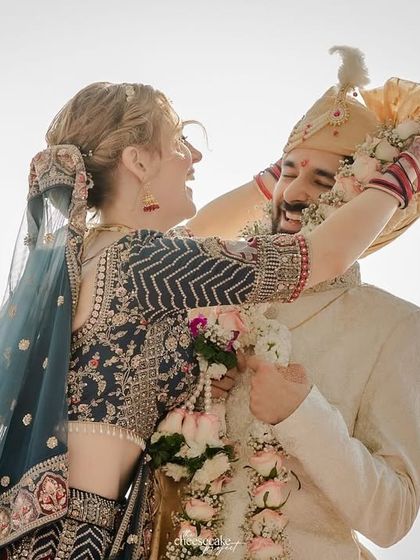 A fun, playful moment during the Varmala at a beautiful beach wedding.