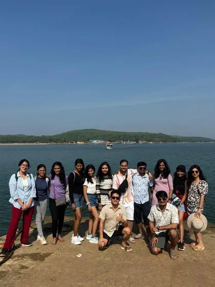 A group of travelers posing on a pier in Gokarna on a bright sunny day.