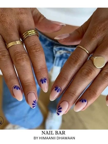 A simple and delicate design with small blue floral patterns at the base of a nude nail.