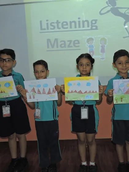 Students proudly show their artwork from the "Listening Maze" activity. This exercise enhances listening skills and the ability to follow directions, all while creating a beautiful piece of art.