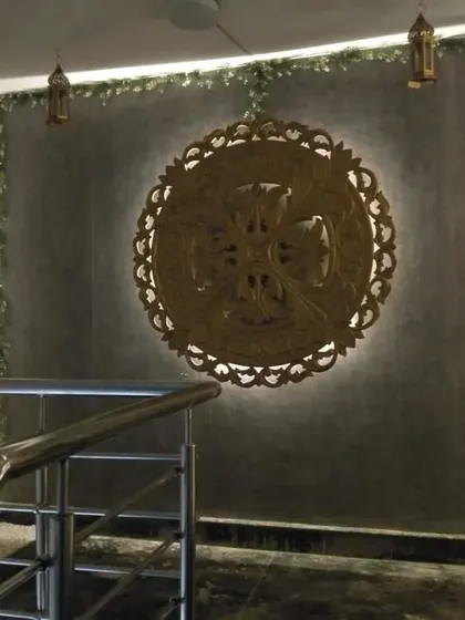 A backlit wooden art medallion at the staircase entrance, welcoming guests with a touch of artistic elegance.