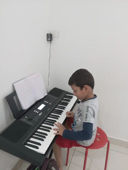 A young boy learning to play the keyboard.