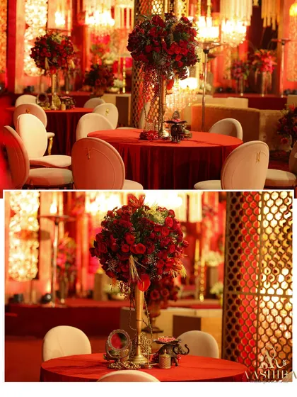 A closer look at the guest tables, where tall arrangements of red roses stood on tables covered in rich red linen, creating a dramatic and romantic dining atmosphere.