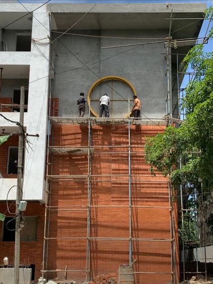 Our team carefully installs the circular frame for a facade emblem. This image captures the scale of the work and the collaborative effort required to execute detailed architectural features.