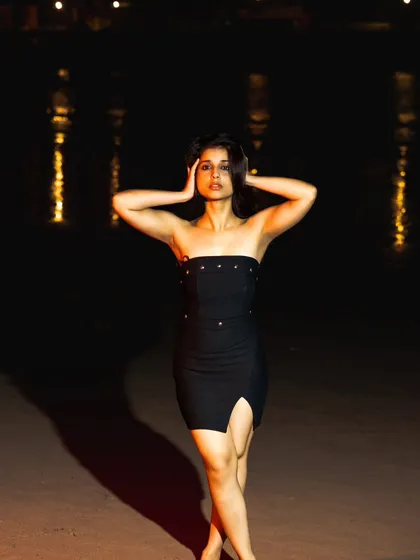 A powerful, confident pose against the dark backdrop of the night sea. The reflections of light on the water add a magical touch.