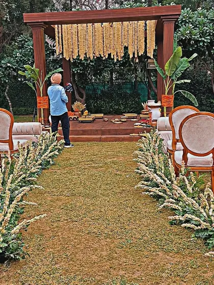The aisle for this garden wedding was lined with lush greenery and white flowers, creating a natural and romantic path to the mandap.