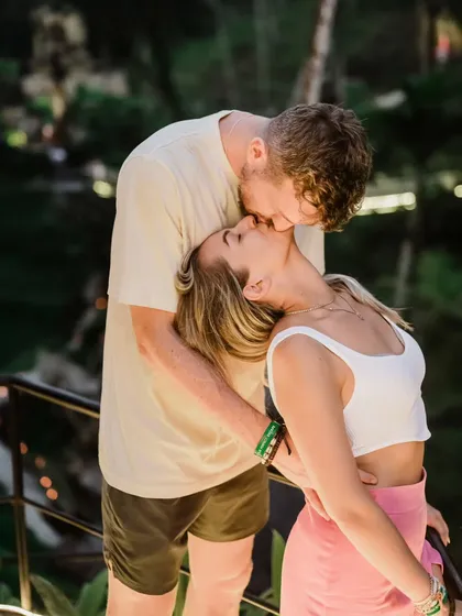 A passionate kiss against the beautiful backdrop of a Balinese resort. This image captures the romantic and luxurious feel of a destination pre-wedding shoot in Bali.
