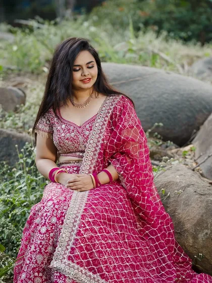A serene portrait of the bride, her pink lehenga spread out around her.