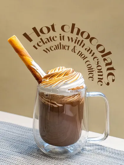 My hot chocolate is perfect for cozy weather. This one is served in a double-walled glass mug, topped with torched meringue and a wafer roll.