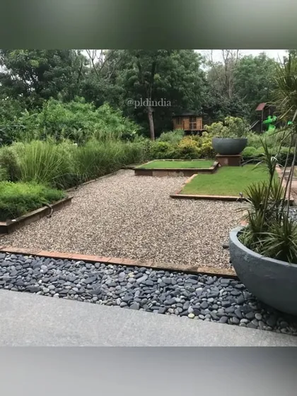 A zen garden court featuring a mix of gravel, river stones, and lawn patches. This minimalist design approach creates a serene and contemplative space that requires minimal maintenance.