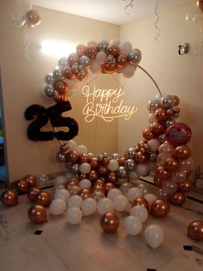 A 25th birthday home decoration with a balloon ring in rose gold, silver, and white, plus a large '25' foil balloon.
