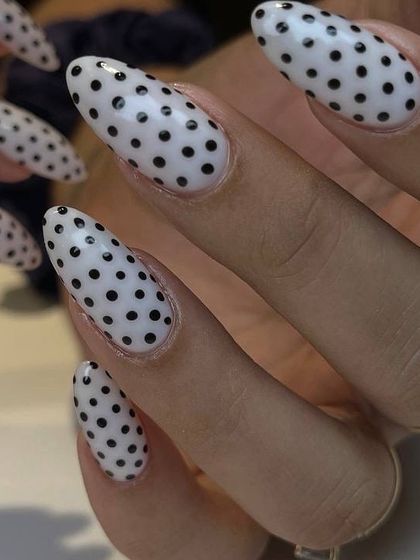 A classic and fun black and white polka dot design on long, almond-shaped nails. This timeless pattern is always a stylish choice.