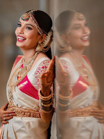 A creative shot showing the bride's happy reflection. Her bright smile and radiant makeup capture the joyful spirit of her wedding day.