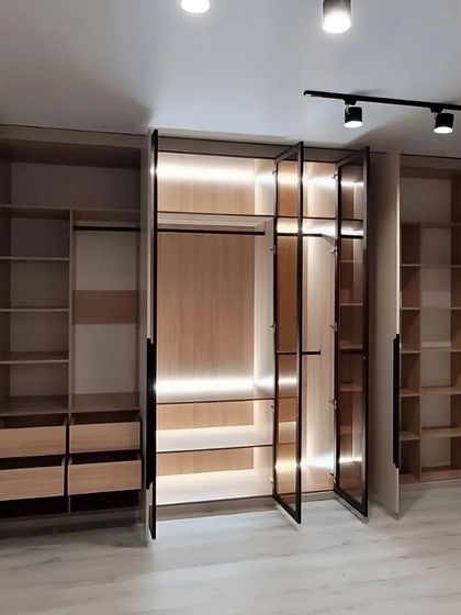 With all doors open, the full functionality of this wardrobe is revealed. The image shows ample hanging space, multiple drawers, and adjustable shelves, demonstrating a commitment to maximum storage and organization.