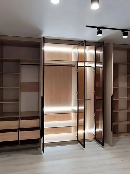 With the doors open, you can see the full extent of the organization inside this wardrobe. It features a mix of hanging space, drawers, and shelves, all designed to maximize storage and accessibility.