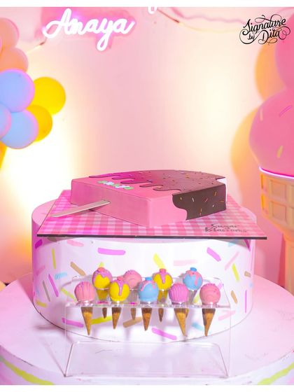 The cake for the ice cream-themed party was a work of art itself, shaped like a melting ice cream bar. It's displayed with mini ice cream cone cake pops.