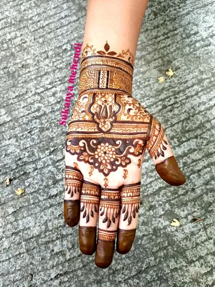 A rich and detailed design for siders or smaller functions, featuring a central floral pattern with intricate bands on the fingers and wrist.