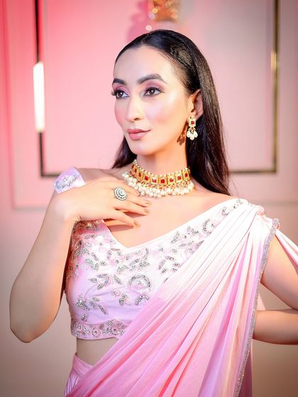 A classic three-quarter portrait pose, highlighting the jewelry and the elegant drape of the saree.