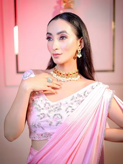 A classic three-quarter portrait pose, highlighting the jewelry and the elegant drape of the saree.