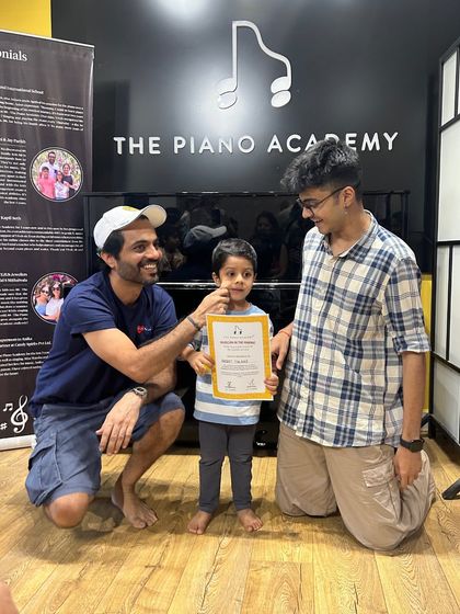 A father and teacher celebrate a young student's successful completion of our music summer camp. These moments of pride and accomplishment are what our community is all about.