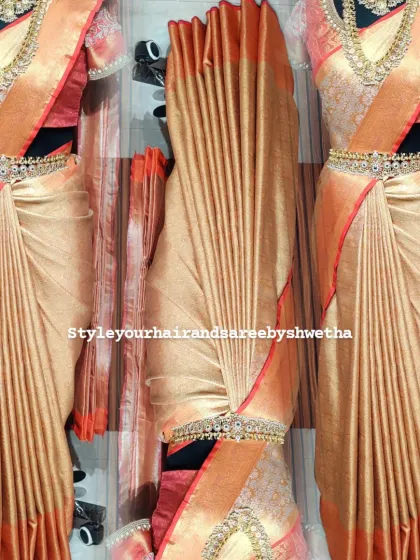 A bridal saree deserves nothing less than perfection. This stunning image showcases the flawless fall of pre-pleated center pleats, complete with a vaddanam, creating an impeccable look for a bride's special day.