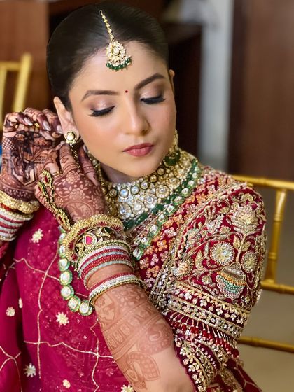 A close-up of the final touches. The soft, rosy makeup and defined eyes are paired with a classic bun, creating a look that is both modern and timeless.