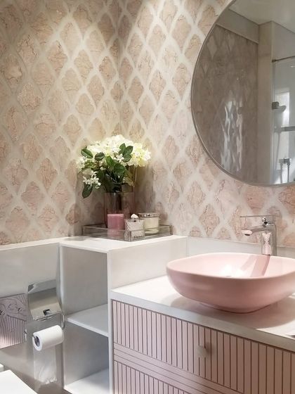 A pink powder room can be incredibly warm and inviting. In this design, we paired soft pink patterned tiles with a matching basin and fluted vanity to create a space that feels chic, modern, and welcoming.