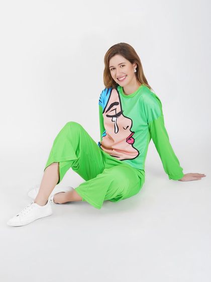 A relaxed, seated pose in a bright green loungewear set. This style of photography is ideal for showcasing comfort and fit for casual apparel collections.