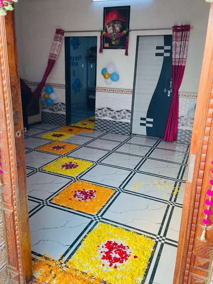 A traditional floor decoration (rangoli) made with marigold and rose petals for a welcome ceremony.