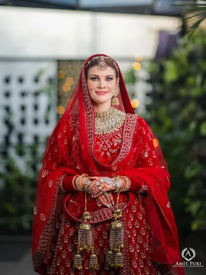 A beautiful portrait of a bride from an NRI wedding. Her traditional red attire, complete with kaleeras, is captured in crisp detail, showcasing her ready and poised for the Anand Karaj ceremony.