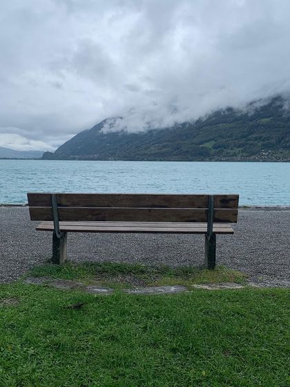 An empty bench by the shimmering water of Lake Brienz in Switzerland. A scene that feels like a poem, a space for quiet thoughts on intimacy and connection.