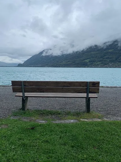 An empty bench by the shimmering water of Lake Brienz in Switzerland. A scene that feels like a poem, a space for quiet thoughts on intimacy and connection.