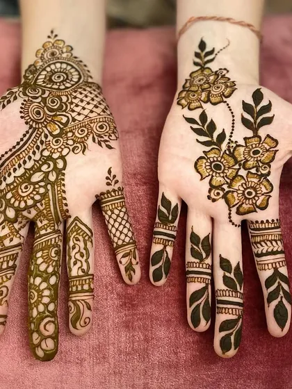 Two different styles for guests. One hand features a delicate Arabic floral vine, while the other has a more detailed Indo-Arabic design.