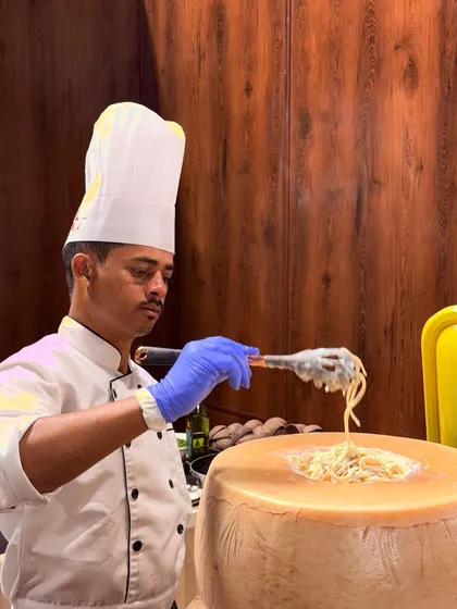 The theatre of live cooking is central to our service. Here, our chef prepares a classic Cacio e Pepe, tossing fresh pasta in a giant wheel of Parmesan cheese for a rich, authentic, and interactive dining experience.