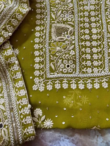 A flat-lay of the suit, showing the dense embroidery on the kurta and the matching work on the dupatta border.
