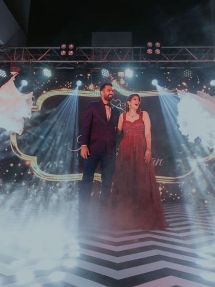 A grand entrance for the engagement, with the couple framed by performers and dramatic smoke effects.